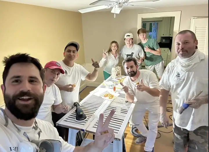 Equipe almoçando numa casa em obra, com os donos da casa