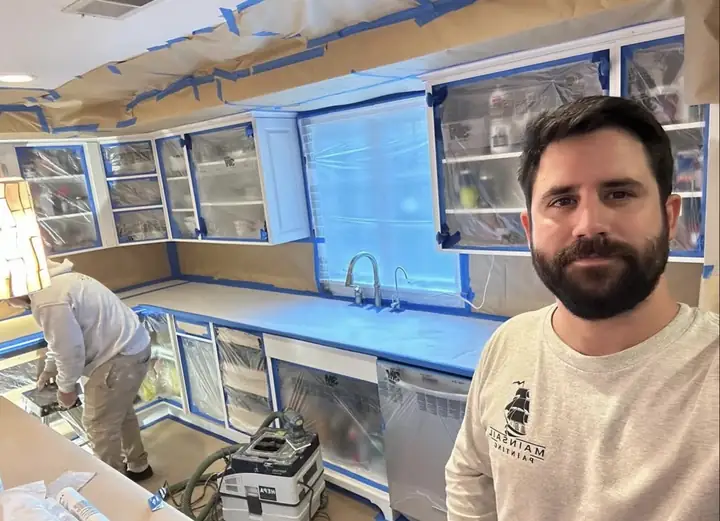 Vini numa cozinha toda protegida com plástico e fita azul